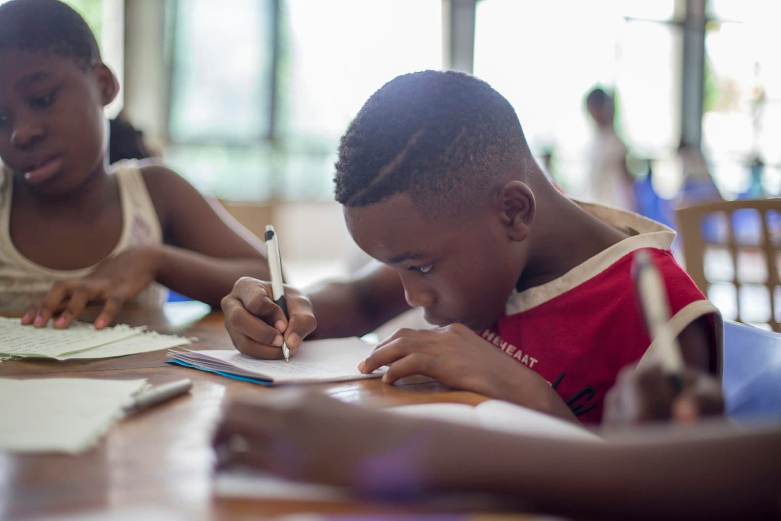 Enfant africain concentré sur son cahier, symbole d’avenir et d’éducation au Cameroun